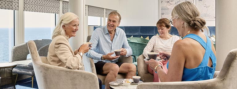 A group of people enjoying coffee in the Britannia Lounge on Spirit of Adventure